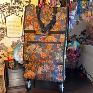 EUC tapestry rolling tote bag features a whimsical, all-over pattern of teddy be